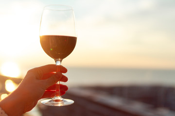A glass of red wine at sunset.