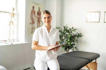 A Modern rehabilitation physiotherapy woman worker at job - obrazy, fototapety, plakaty