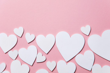 White hearts on a pastel pink background. 