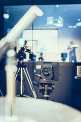 Modern film camera on a tripod in a broadcasting studio, spotlights and other equipment