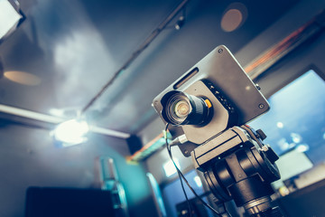 Modern film camera on a tripod in a broadcasting studio, spotlights and other equipment