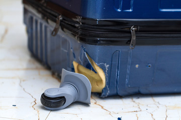 Traveling suitcase damaged at the airport. Broken luggage wheel