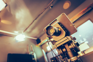 Modern film camera on a tripod in a broadcasting studio, spotlights and other equipment