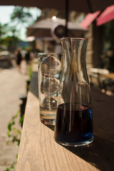  a glass full of ice and a bottle of lavender lemonade on the table