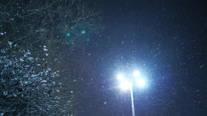 Snow falling on night winter city street. Yekaterinburg, Russia. Slow motion.