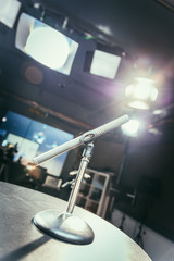 Fototapeta na wymiar Microphone in the recording studio, equipment and lighting in the blurry background