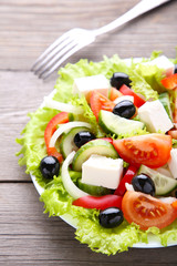 Fresh vegetable salad with fork on grey background