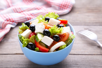 Fresh vegetable salad with fork on grey wooden background