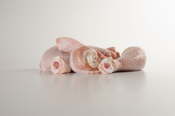 Four pieces of raw chicken meat on a light background