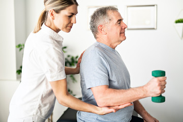 A Modern rehabilitation physiotherapy worker with senior client