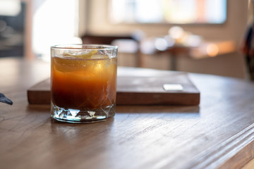 Lemon slices in Iced Americano coffee glass and sugar bottle in coffee shop
