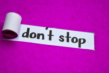 Don't Stop text, Inspiration, Motivation and business concept on purple torn paper