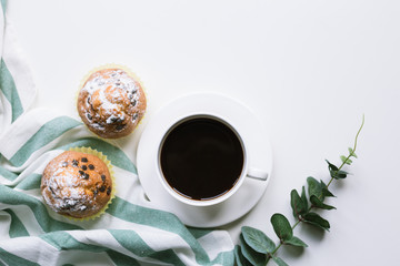 Coffee and two muffins on white background