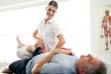 A Modern rehabilitation physiotherapy worker with senior client