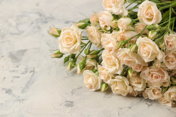 A bouquet of beautiful tender mini roses on a light concrete background. space for text