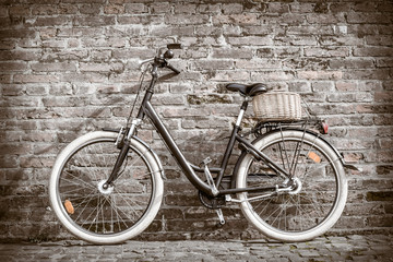 Fototapeta na wymiar Black retro vintage bicycle with old brick wall.