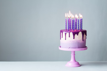 Birthday cake with drip icing and purple candles
