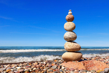 High Rock zen pyramid of white and pink pebbles on a background of blue sky and sea.