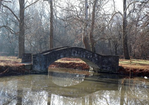 The old stone footbridge in the park on a winter day.
