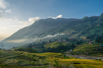 Beautiful Panorama Top view of growing golden paddy rice field in Tavan local village with fansipan mountain and cloudy sky in background, Sapa, Laocai , Northwest of Vietnam