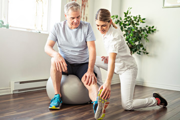 A Modern rehabilitation physiotherapy worker with senior client