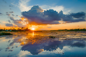 sunset sky with clouds above lake, tourist attraction Nong Han lake at Sakon Nakhon province in thailand