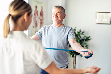 A Modern rehabilitation physiotherapy worker with senior client