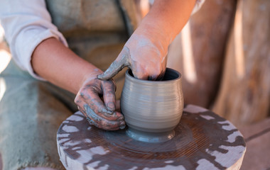 Potter is creating earthenware on potter's wheel.