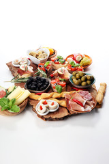 Italian antipasti wine snacks set. Cheese variety, Mediterranean olives, pickles, Prosciutto di Parma, tomatoes, artichokes