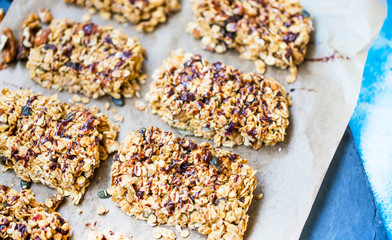 Fototapeta na wymiar Homemade granola bars with oats, nuts, seeds and chocolate syrup