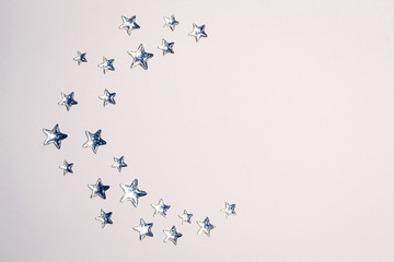 Beautiful Crescent concept made of shining silver stars with embossed transparent top on white background. Copy space. Top view.