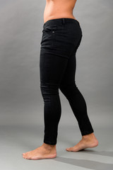 Modern male unbranded Black skinny jeans isloated on grey background