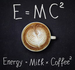 The cup of black coffee with milk and two funny formulas. Night sky background.