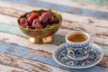 Turkish coffee and dates on turquoise table side view