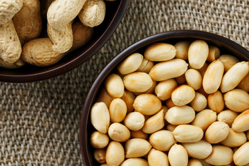 Peanuts in the shell and peeled closeup in a cup