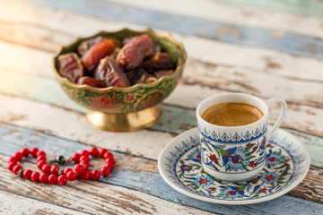 Turkish coffee, dates, and red rosary on turquoise table side view