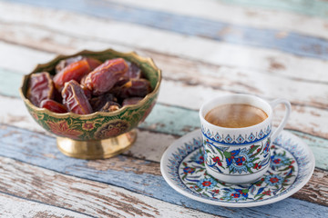 Turkish coffee and dates on turquoise table side view