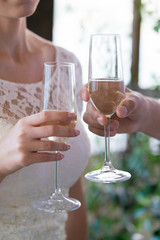 newlyweds are holding champagne glasses and clink glasses
