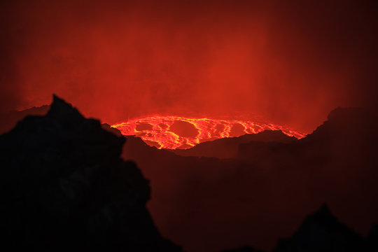 Amazing and breathtaking view of boiling lava lake at the bottom of Erta Ale active volcano at Danakil depression, Tigray region, Ethiopia, Africa. Crater border on foreground, selective focus