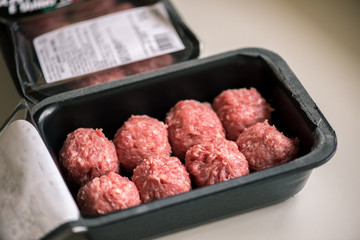 Opened pack of raw meatballs from the supermarket