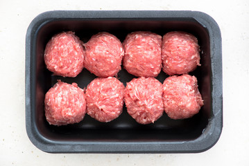 Raw fresh meatballs in black tray, top view