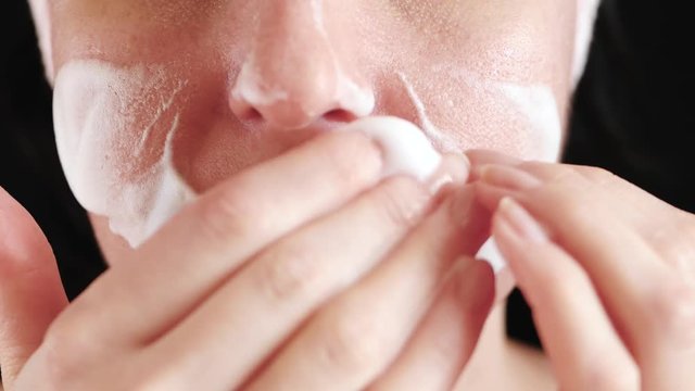 Woman with problem skin and enlarged pores close-up. The girl cleans the face with foam. The concept of natural cosmetics and acne prone skin care.