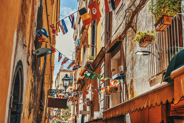 Fototapeta na wymiar Flags on a narrow alley in old town Sorrento