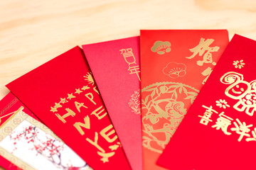 Red envelope packet chinese new year, hongbao with the character 'Happy New Year' on wood background for Chinese New Year. Translation: Good luck in the year