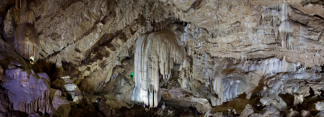 Panorama of a deep mountain cave with huge stalactites.