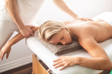 Obraz na płótnie Canvas A Woman enjoying spa treatment at salon with masseur worker