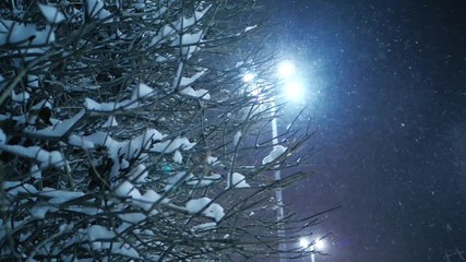 Snow falling on night winter city street. Yekaterinburg, Russia. Slider shot