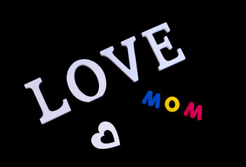 Word love in white and also white heart and colored word mom over black background