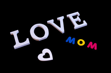 Word love in white and also white heart and colored word mom over black background