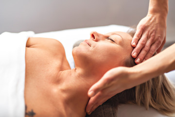 Fototapeta na wymiar A Woman enjoying spa treatment at salon with masseur worker